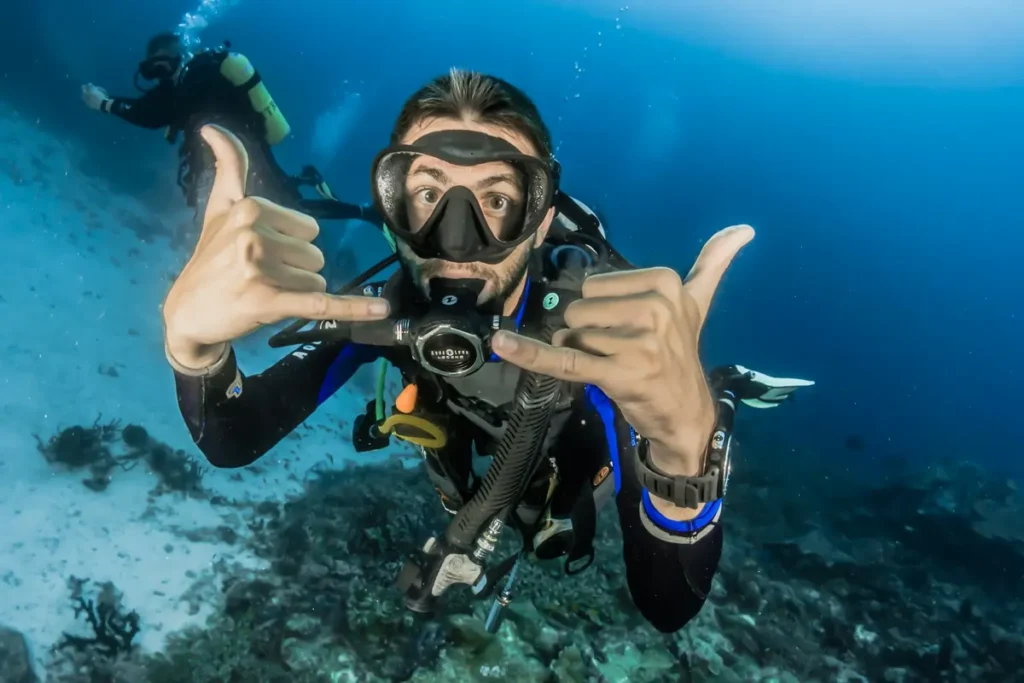 A male scuba diver giving the "shaka" sign to the camera while enjoying some of the best diving in Southeast Asia in Koh Tao, Thailand.