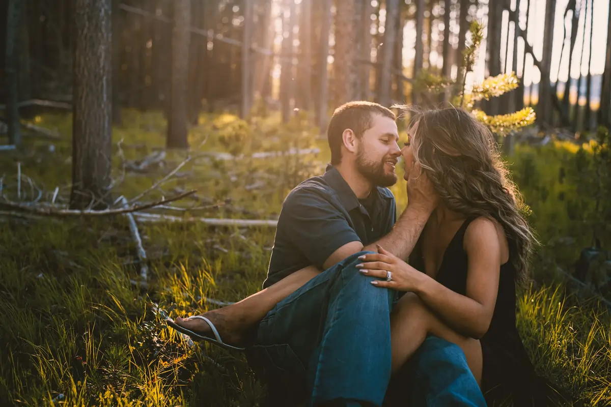 A couple sharing a romantic moment in a sunlit forest, one of the Best Places To Travel In Montana For Couples.