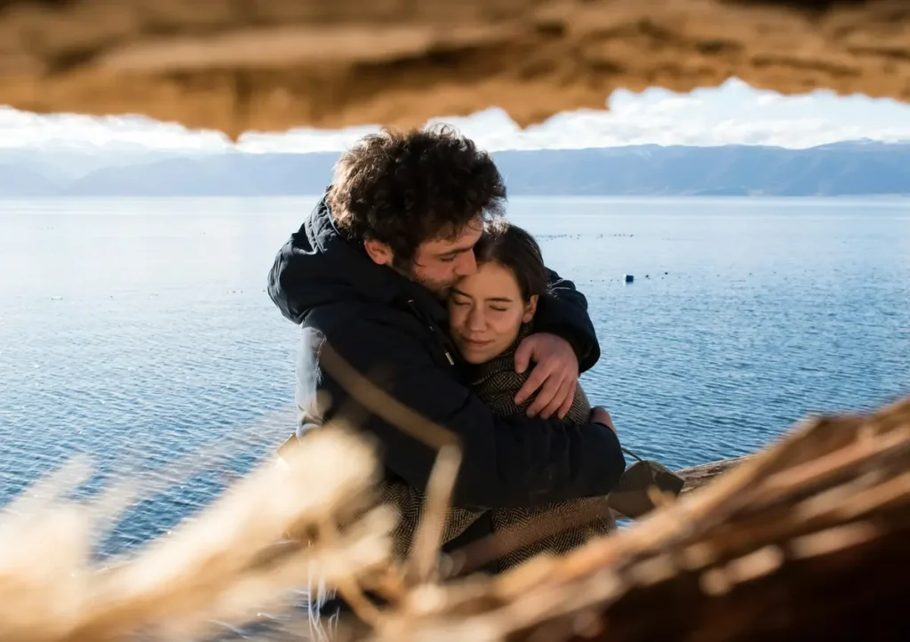 A couple embracing warmly by the shore of Lake McDonald, one of the Best Places To Travel In Montana For Couples.