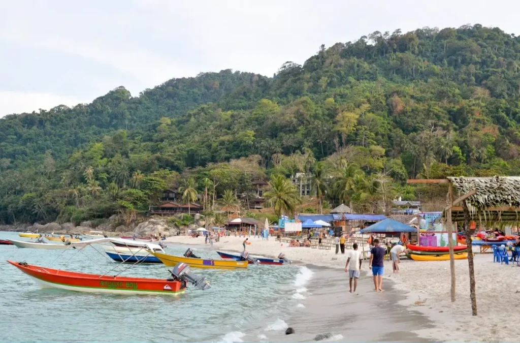 A bustling beach scene in the Perhentian Islands, Malaysia, an ideal location when Planning Your Southeast Asian Diving Adventure.