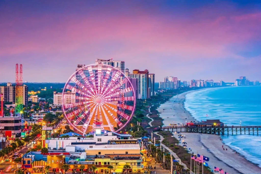 Carolina Beach Boardwalk at dusk featuring colorful amusement rides and lively crowds near the ocean
