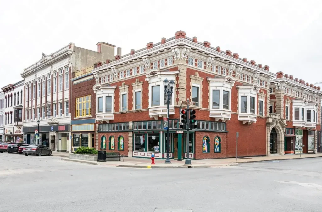 A street corner in historic downtown Leavenworth, Kansas, featuring ornate 19th-century red brick and white stone buildings, showcasing the city's rich architectural heritage.