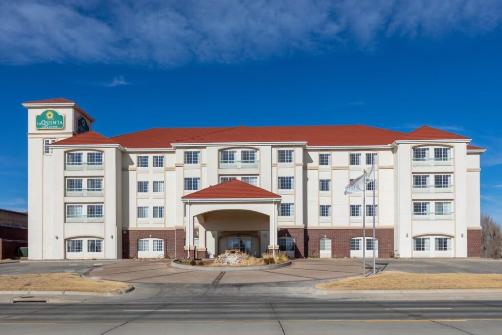 The exterior of the La Quinta Inn & Suites by Wyndham hotel in Dodge City, Kansas, a reliable and family-friendly accommodation option, shown on a clear, sunny day.