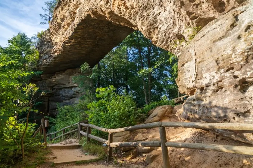 Natural Bridge sandstone arch at Natural Bridge State Resort Park in Kentucky framed by lush greenery and a clear sky