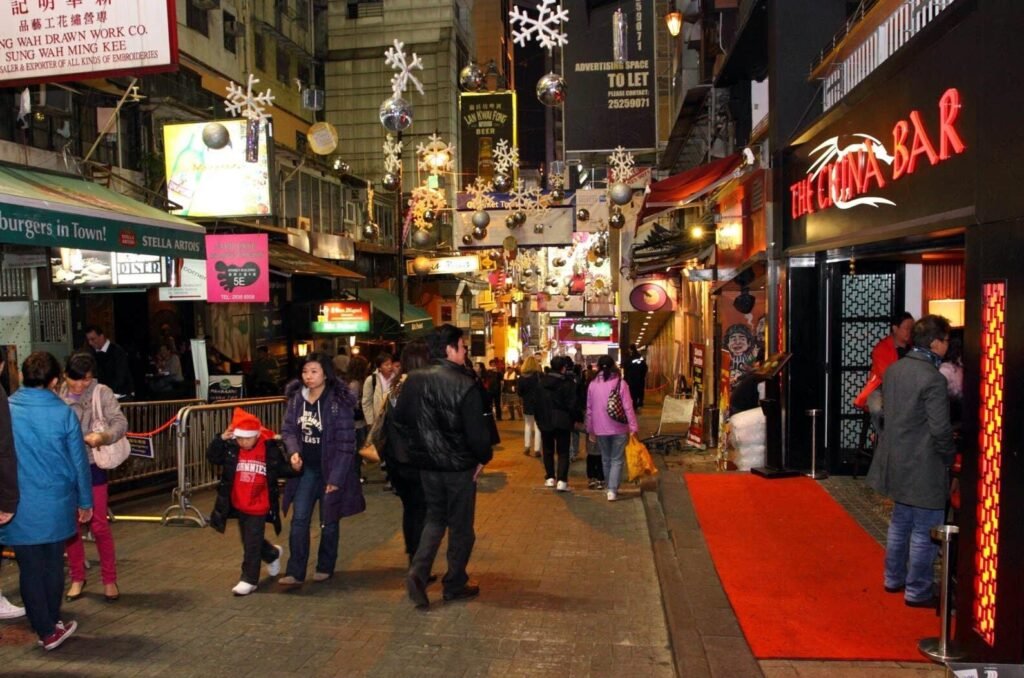 The crowded nightlife district of Lan Kwai Fong in Hong Kong, one of the top cities in Asia for nightlife, with people walking down a narrow street full of bars.