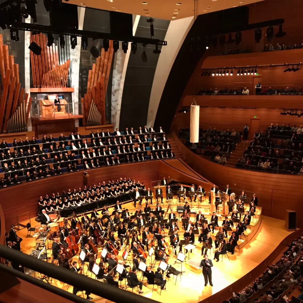 Symphony orchestra and choir performing at Kansas City Music Hall in a grand concert setting