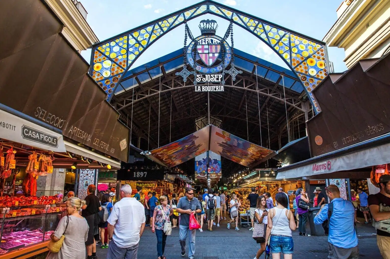 The bustling entrance to La Boqueria market, a popular stop on many Barcelona tours, with people shopping at the various stalls.