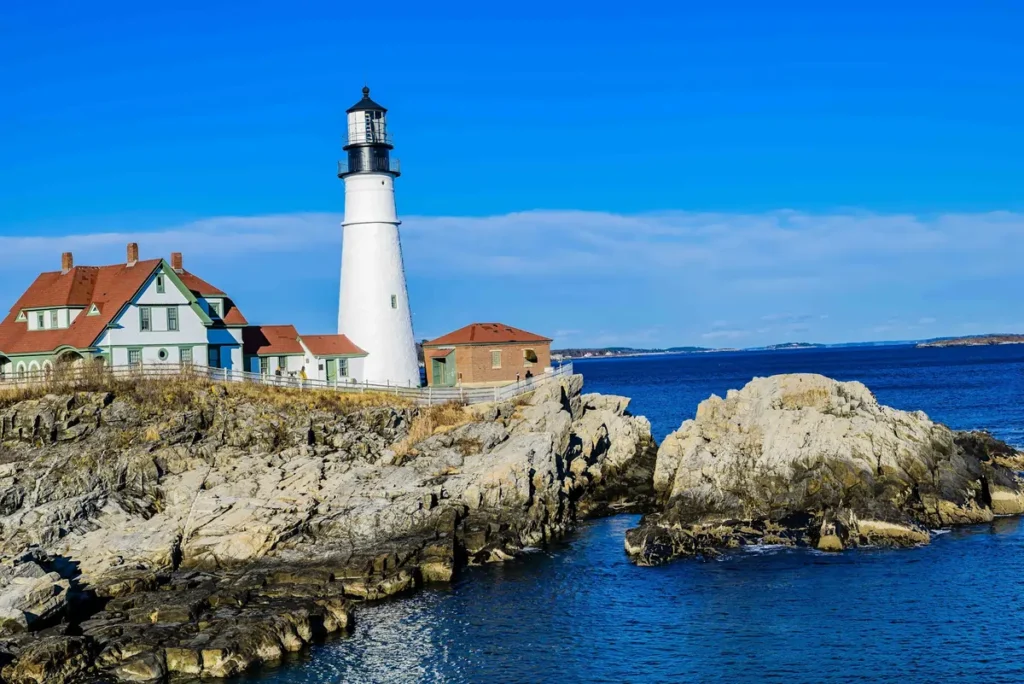 The historic Portland Head Light in Cape Elizabeth, Maine, a classic landmark for a romantic getaway in New England, standing on a rocky coast.