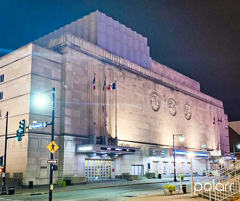 Night view of the Kansas City Municipal Auditorium Music Hall facade with illuminated marquee and flags
