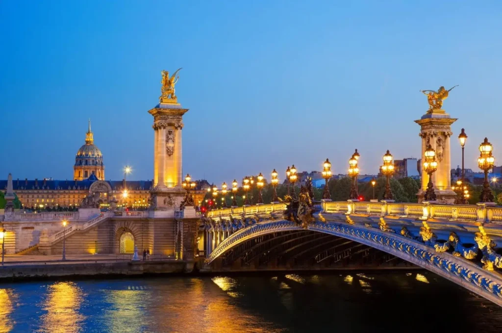 Pont Alexandre III bridge in Paris illuminated at night, capturing the city's romantic ambiance