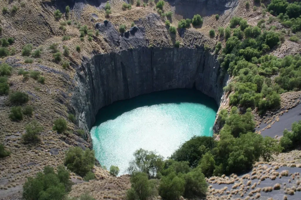 The Big Hole in Kimberley, a massive former diamond mine now filled with turquoise water, representing the history of one of the most unique cities in South Africa.