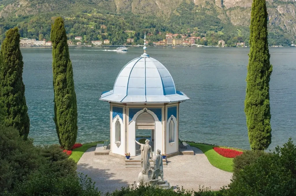 Neoclassical garden pavilion at Villa Melzi Bellagio overlooking Lake Como with cypress trees and sculpture